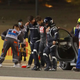 Romain Grosjean is lead away from a crash by the F1 medical team